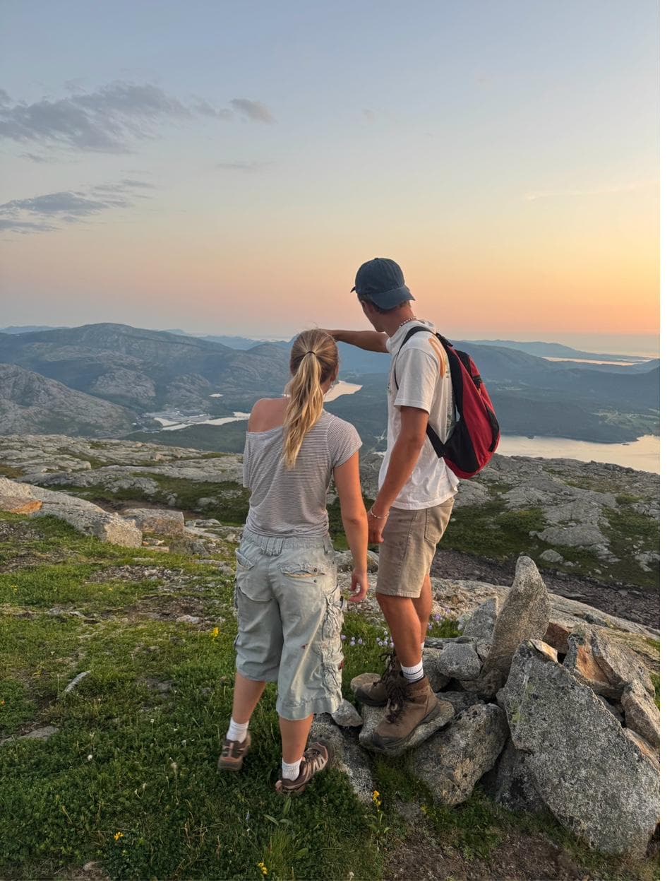 To turgåere på fjelltopp i solnedgang