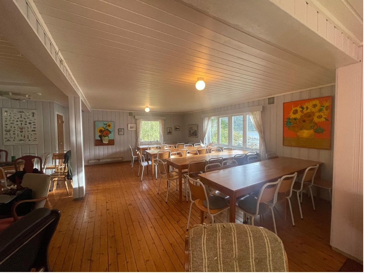 Samlingsrom med bord og solsikkemalerier